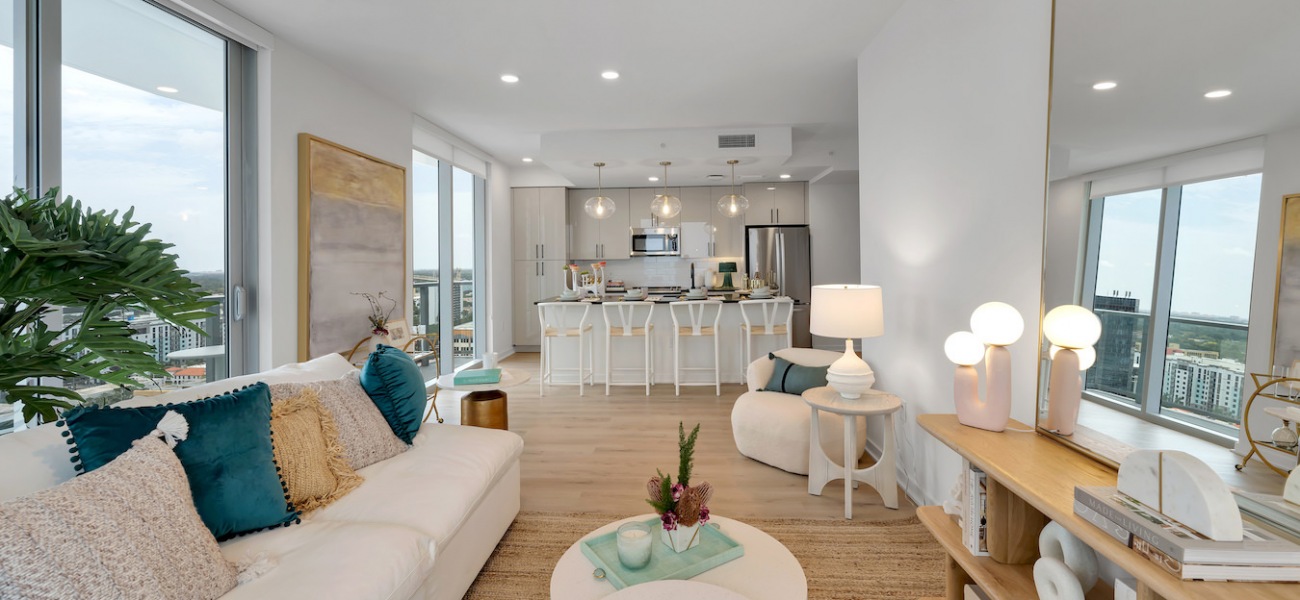 light filled living area sofa coffee table mirror kitchen island barstools windows light filled living area sofa coffee table mirror kitchen island barstools windows