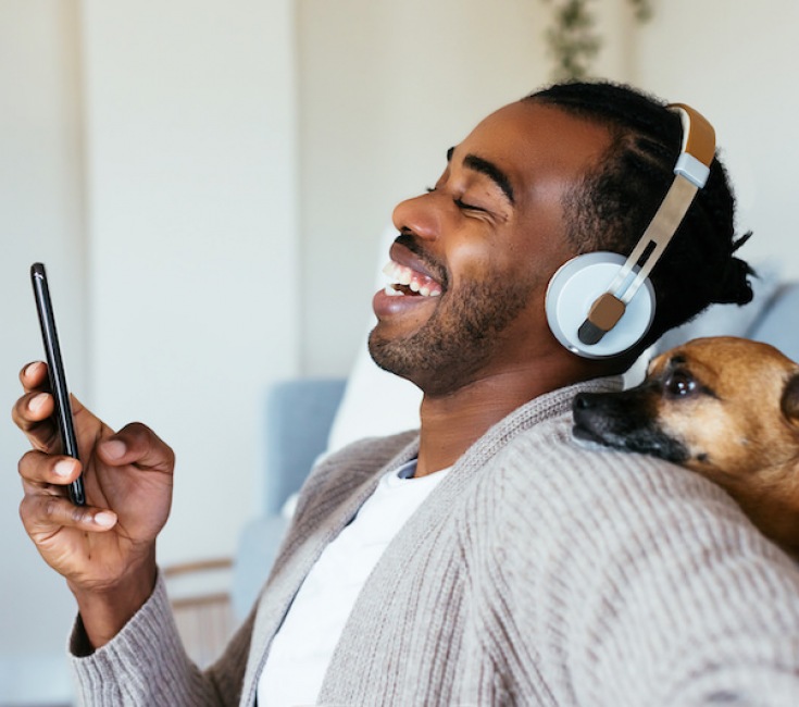 Man listening to music with is dog 